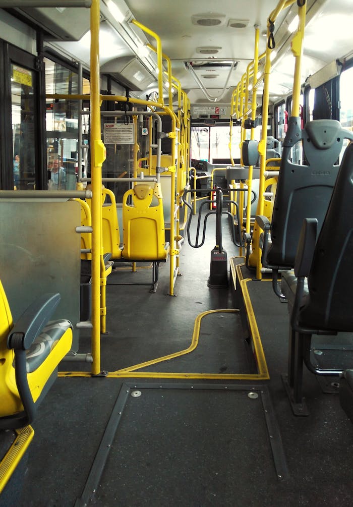 services-01 An empty bus with yellow seats and handrails in São Paulo, highlighting urban transportation.
